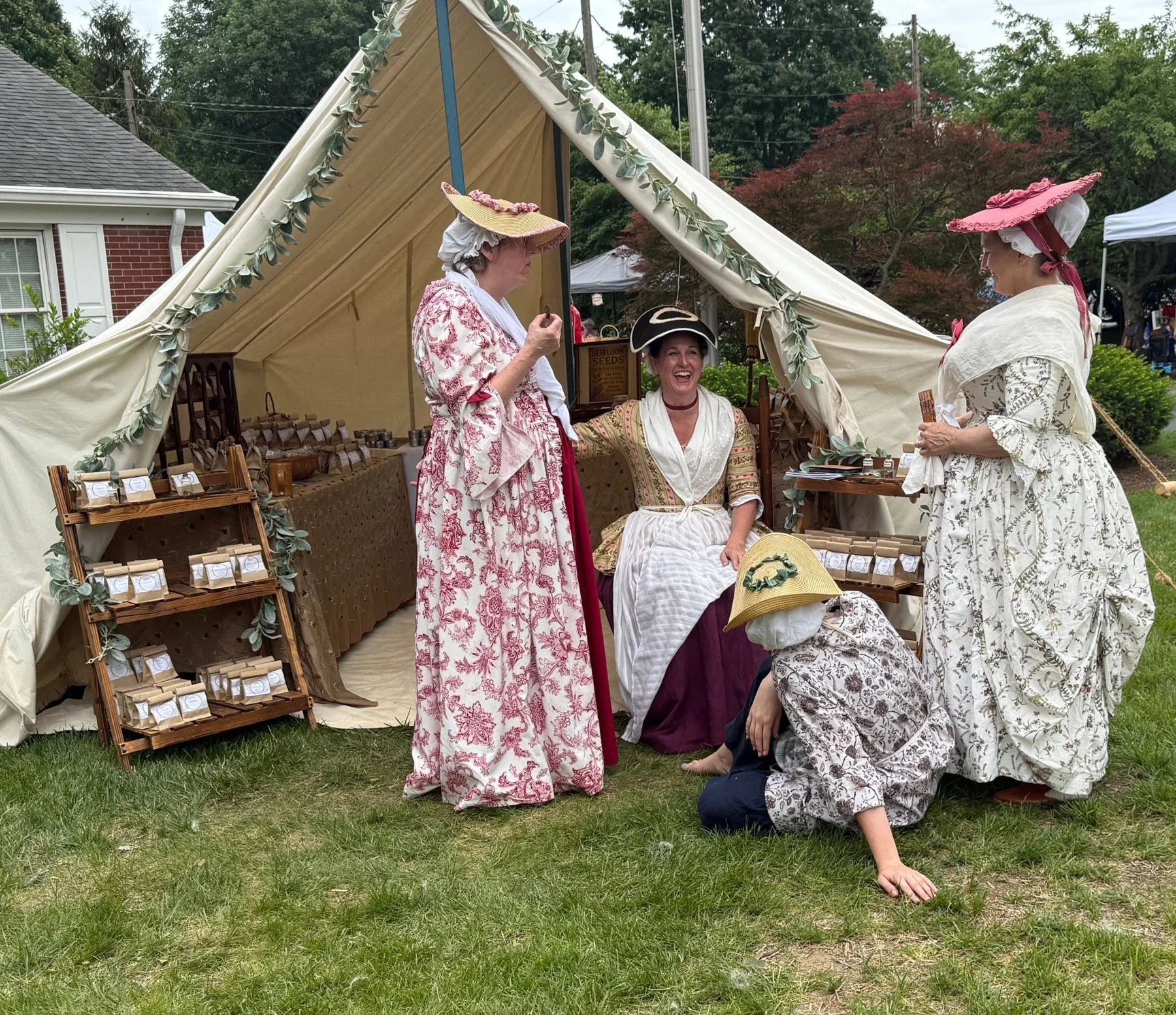 Costumed interpreters gather beside a canvas tent.