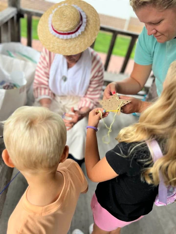 Children join a costumed interpreter for a hands-on activity.