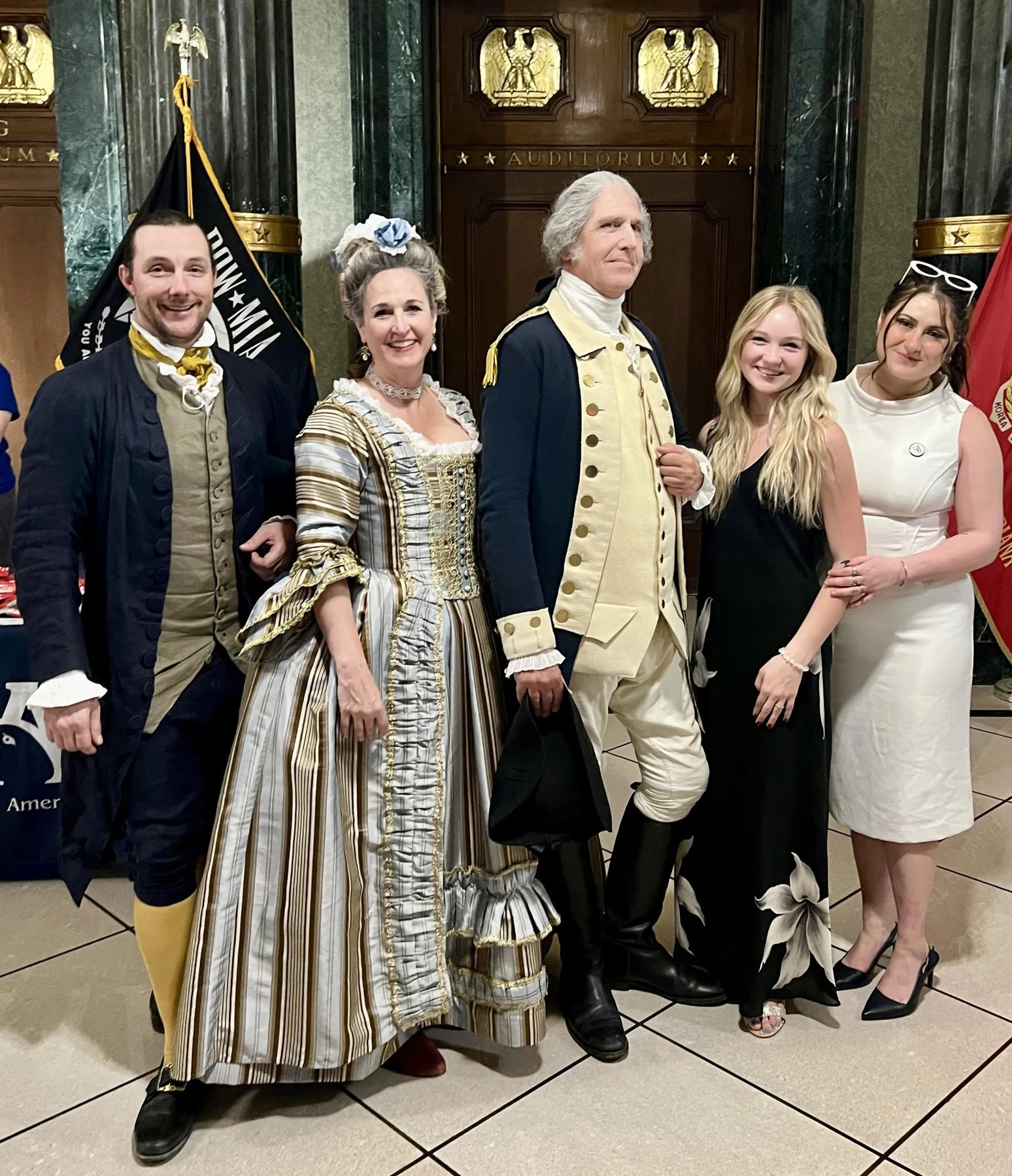 Jen in a formal period gown stands with costumed interpreters and guests.