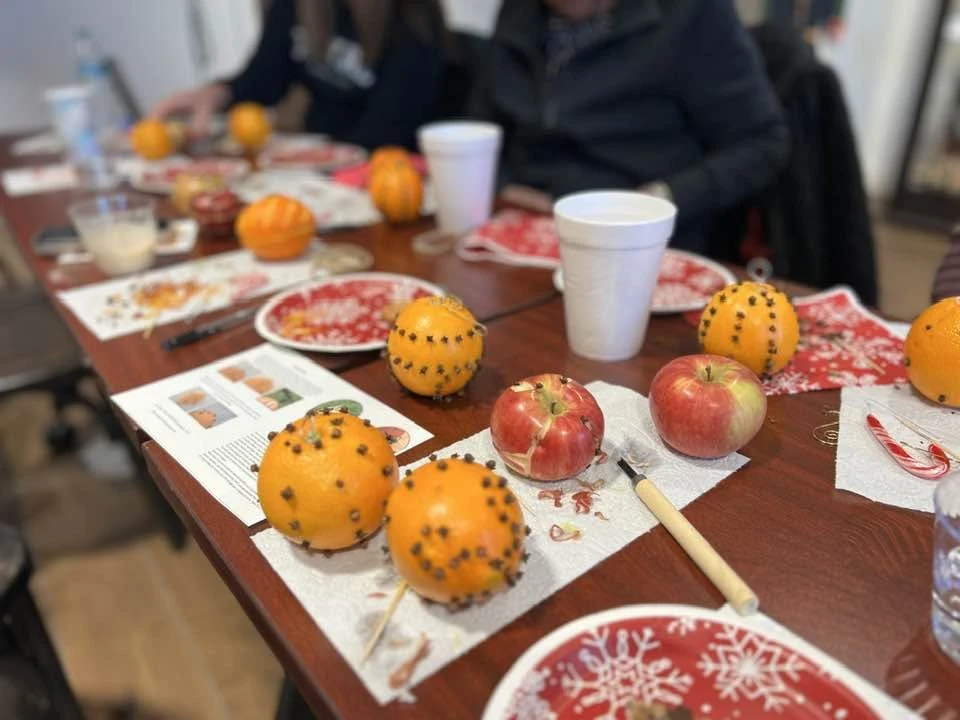 Clove-studded oranges and other fruit arranged on a workshop table.